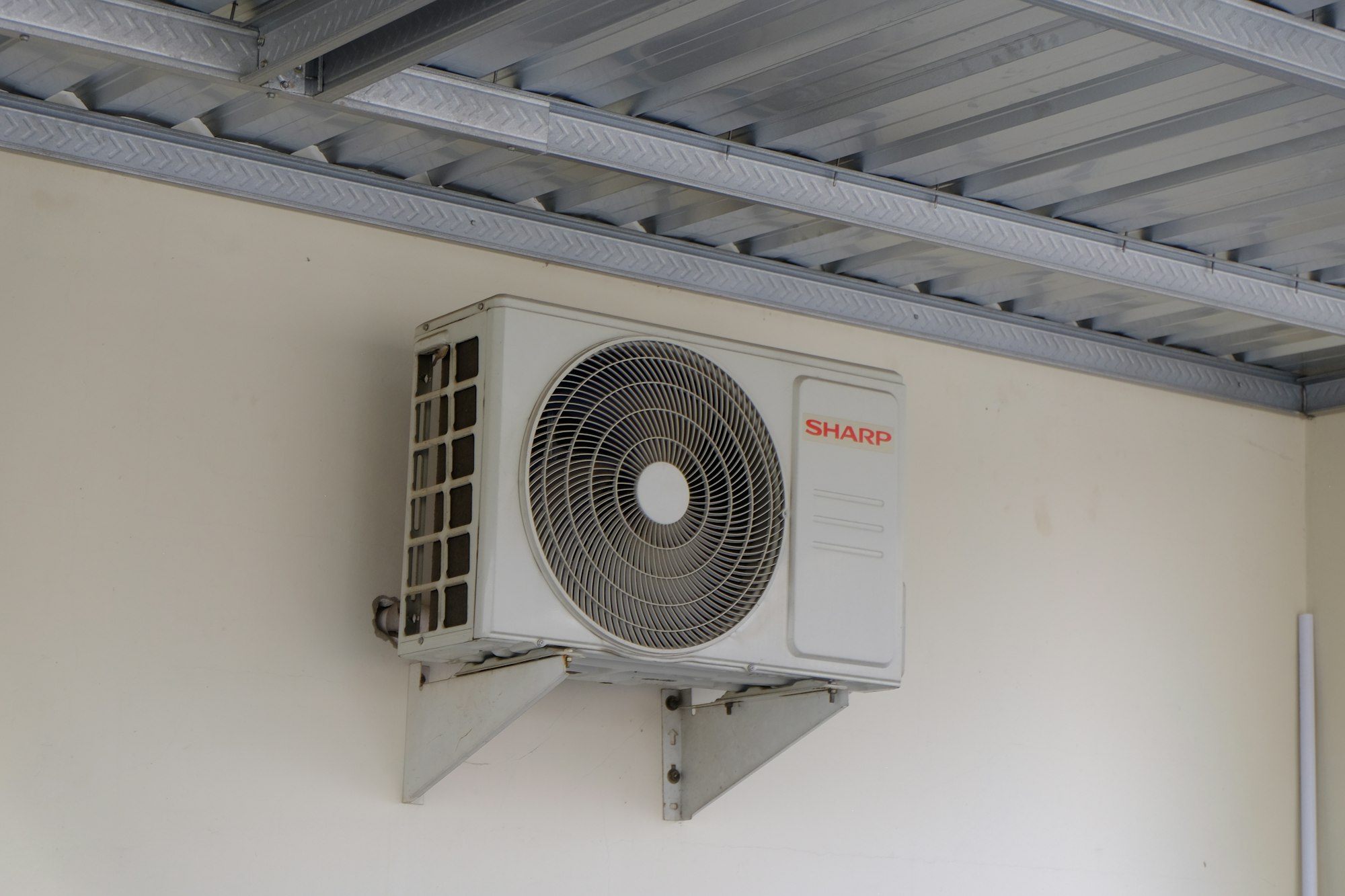 Outdoor mini-split condenser mounted on a wall bracket